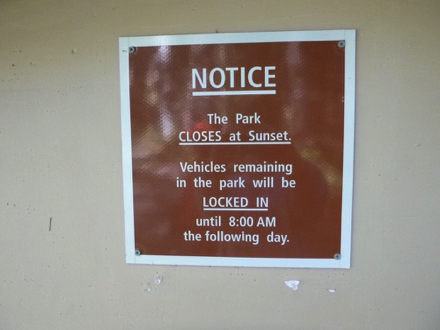 Sign – NOTICE – park closes at sunset – vehicles remaining in park will be locked in until 8 am the next day